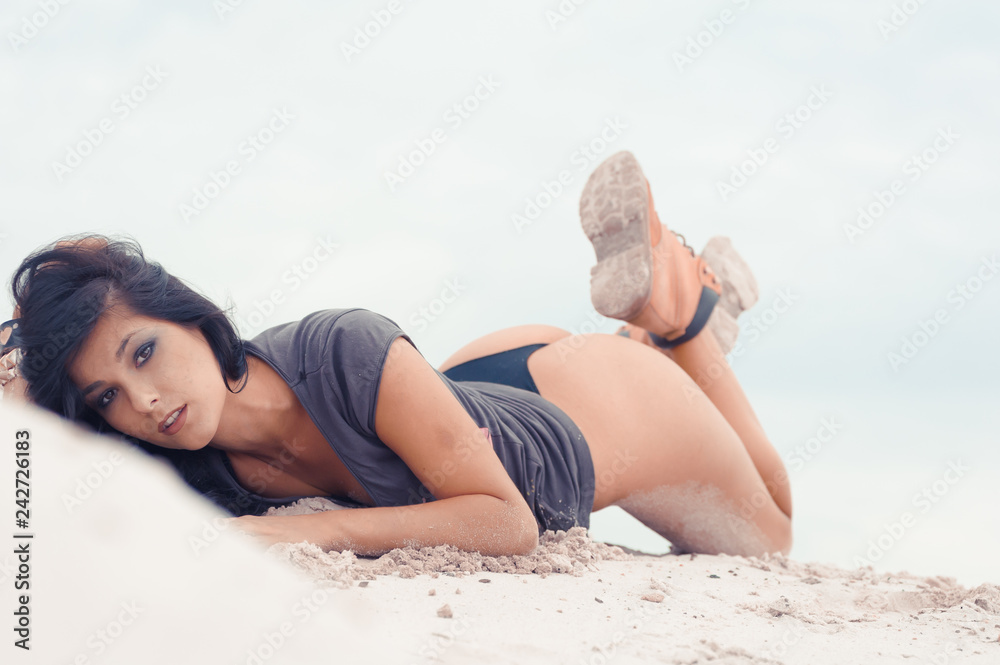 Beautiful sensual black haired woman in safety boots on sand dunes Beautiful sensual black haired woman in safety boots on sand dunes