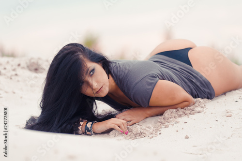 Beautiful sensual black haired woman  in safety boots on sand dunes