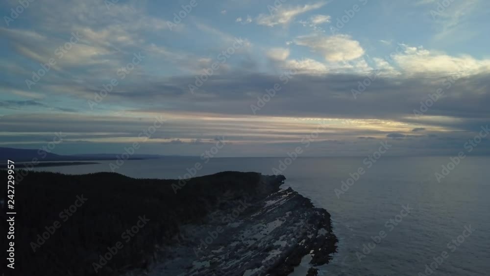 Aerial view of a rocky shore on the Atlantic Ocean Coast during a vibrant sunny sunset. Taken in Cow Head, Newfoundland, Canada. Aerial view of a rocky shore on the Atlantic Ocean Coast during a vibrant sunny sunset. Taken in Cow Head, Newfoundland, Canada.