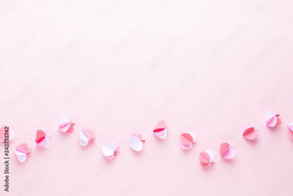 Colorful paper garland of hearts on the living coral background. Valentine day greeting cards.