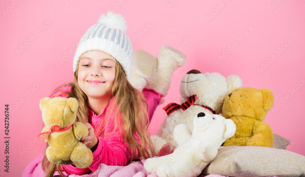 Kid little girl play with soft toy teddy bear pink background. Softness is key. Child small girl playful hold teddy bear plush toy. Bears toys collection. Teddy bears improve psychological wellbeing