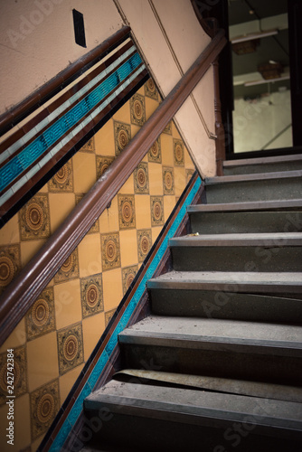 Beautiful brown and aqua pristine original art deco tiles in an old forgotten 1920 dance hall in England. Historic vintage antique memorabilia and design. staircase and bannister.