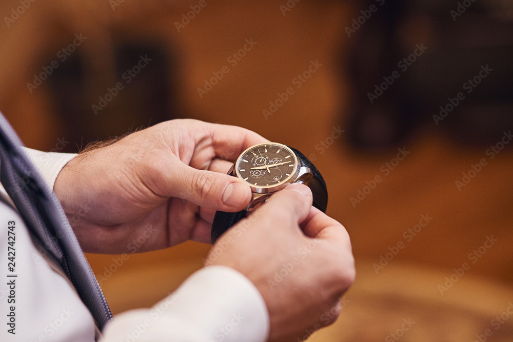 businessman checking time on his wrist watch, man putting clock on hand,groom getting ready in the morning before wedding ceremony businessman checking time on his wrist watch, man putting clock on hand,groom getting ready in the morning before wedding ceremony