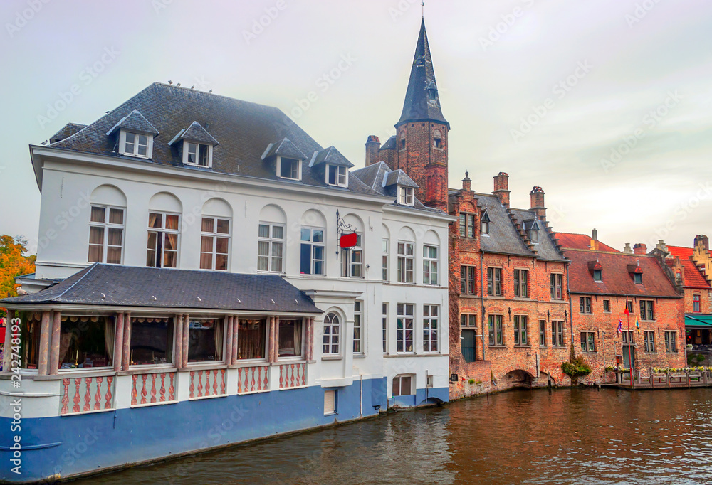 Streets of Bruges in Belgium with its medieval style facades on a cloudy day.