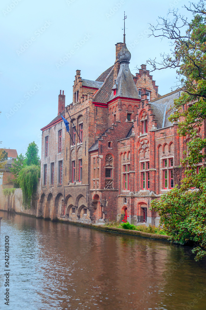 Streets of Bruges in Belgium with its medieval style facades on a cloudy day.