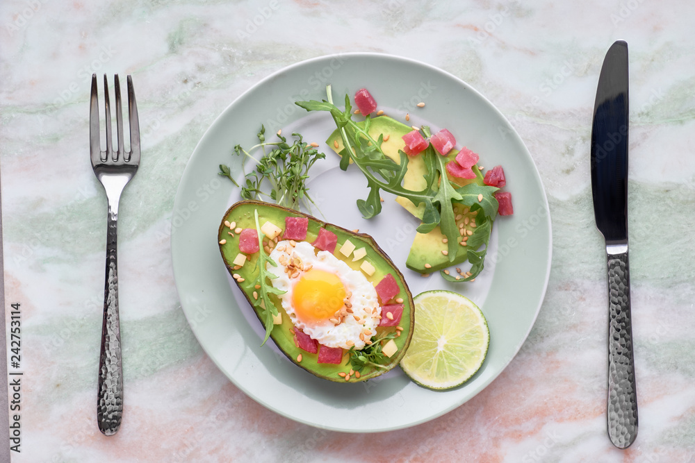 Baked Avocado boat with ham cubes, quail egg and cheese served with green rucola salad Baked Avocado boat with ham cubes, quail egg and cheese served with green rucola salad