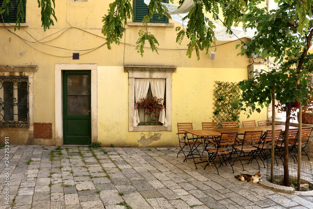 Charming cafe in a colorful narrow street in Sibenik, Croatia. Traditional Mediterranean architecture. Selctive focus.
