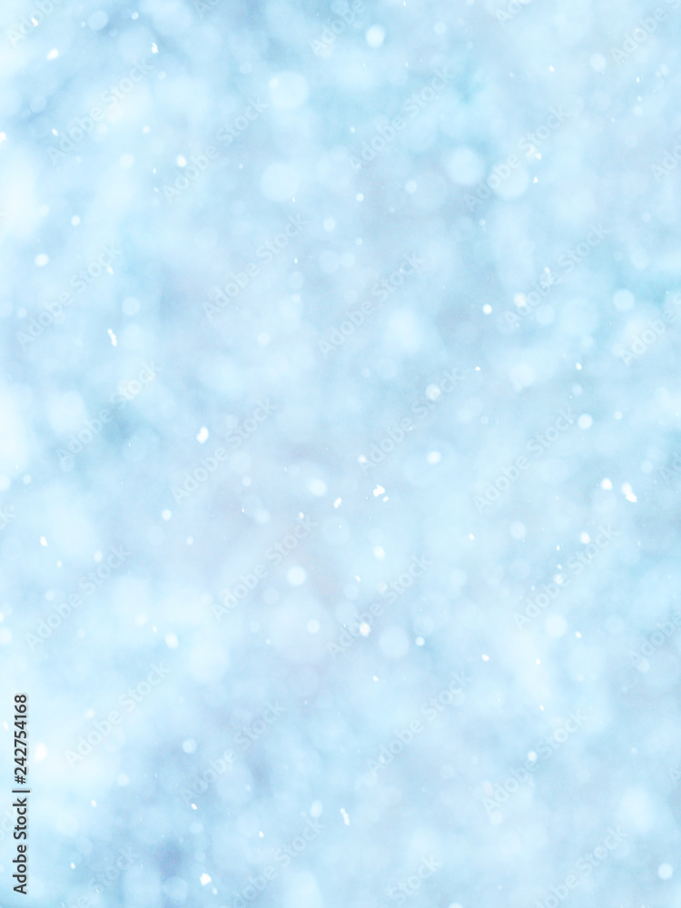 Snowing. Vertical abstract soft natural winter background,  falling snowflakes. Light blue tone