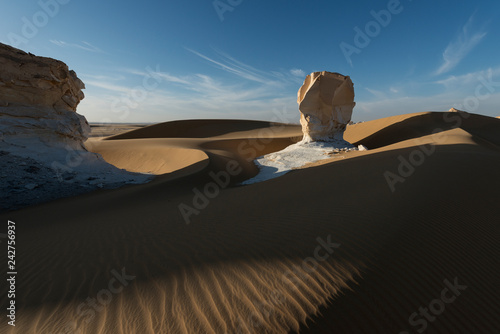 Amazing sunset landscape showing white chalk limestone rock formations in the Egyptian White Desert National Park photo
