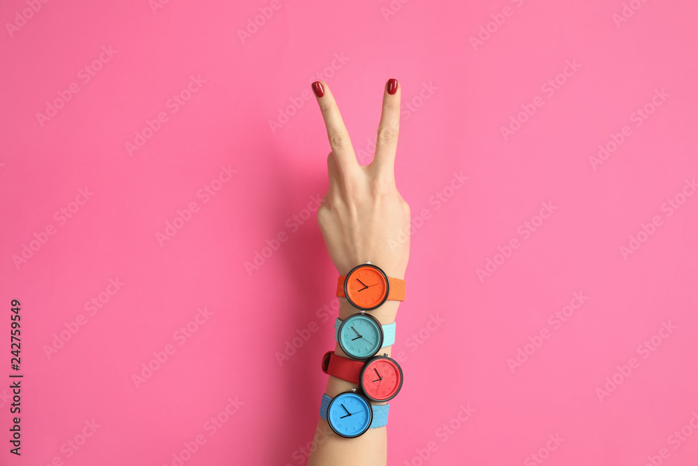 Woman with many bright wrist watches on color background, closeup. Fashion accessory - obrazy, fototapety, plakaty 