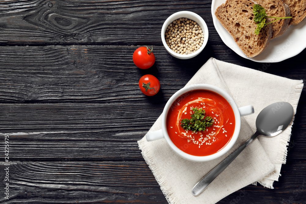 Fresh homemade tomato soup served with bread on wooden table, top view. Space for text Fresh homemade tomato soup served with bread on wooden table, top view. Space for text