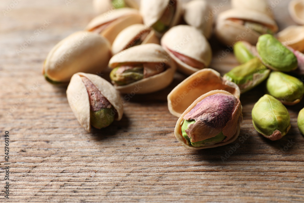 Organic pistachio nuts on wooden table, closeup Organic pistachio nuts on wooden table, closeup