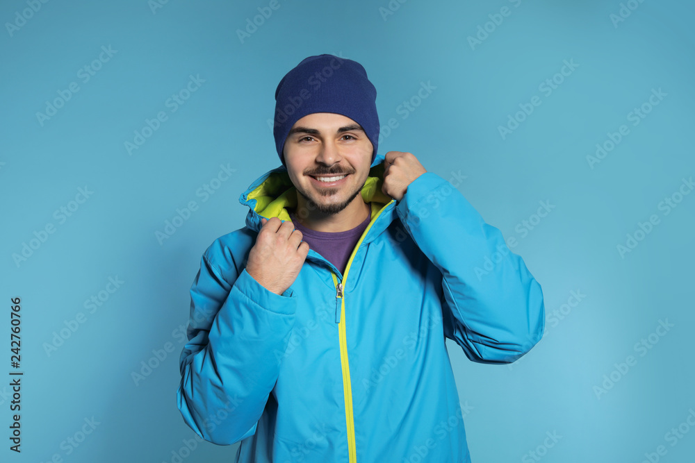 Young man wearing warm clothes on color background. Ready for winter vacation Young man wearing warm clothes on color background. Ready for winter vacation