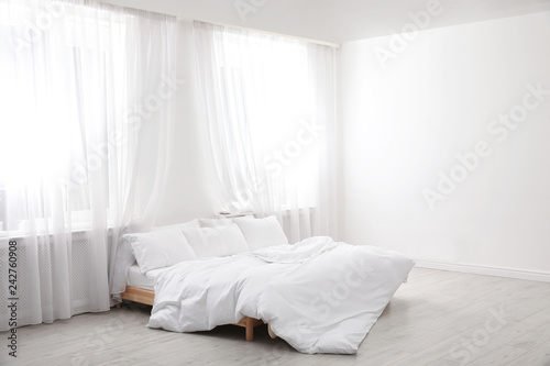 Comfortable bed in light room. Interior design © New Africa