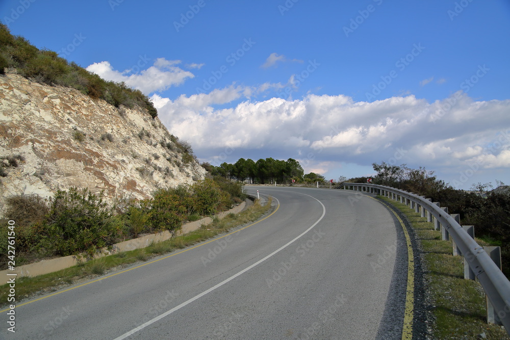 Left curve road in mountains area, blue sky with nice white clouds, empty