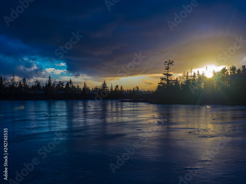 Winter sunset over frozen lake, Nova Scotia, Canada.