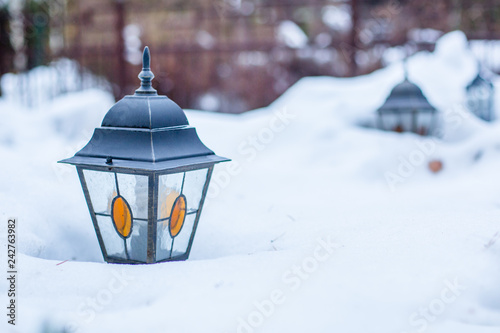 Garden lantern in the winter garden in the middle of the snow. © liubovyashkir