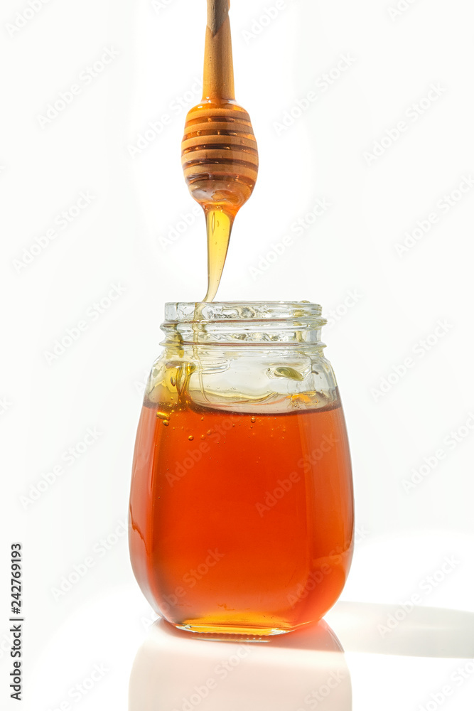 Bee honey with a wooden spoon for honey.isolated objects on white background Bee honey with a wooden spoon for honey.isolated objects on white background