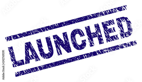 LAUNCHED seal print with distress style. Blue vector rubber print of LAUNCHED title with retro texture. Text title is placed between parallel lines.