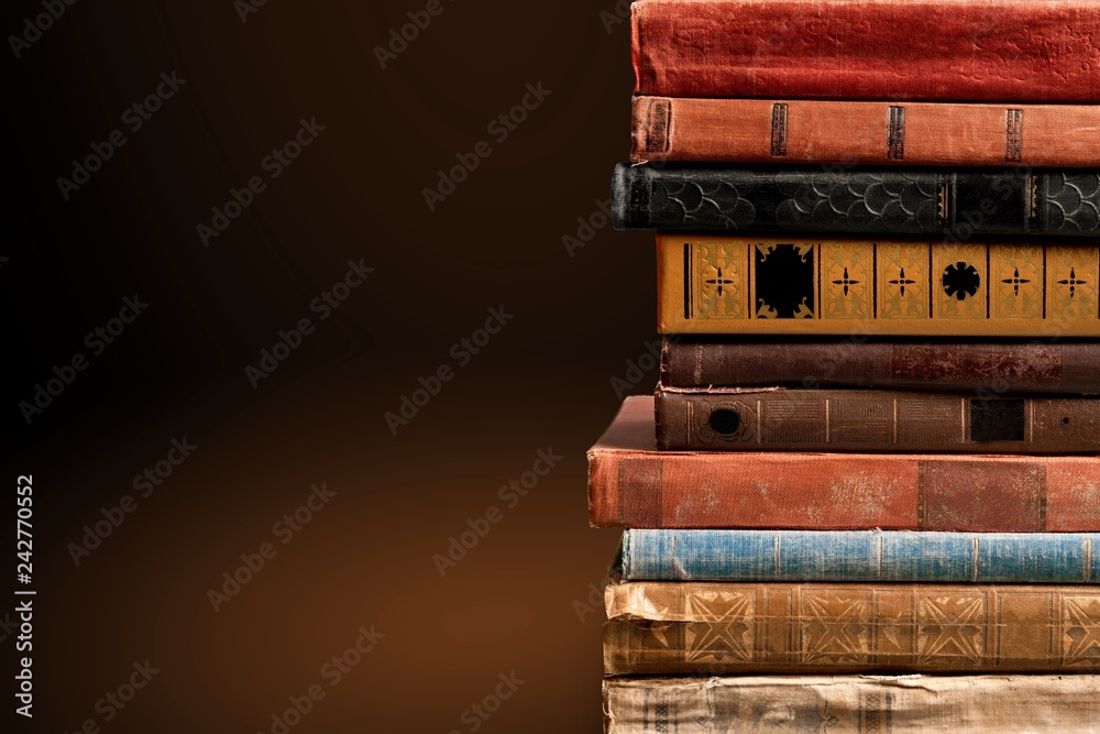 Collection of old books on wooden table on room background Collection of old books on wooden table on room background