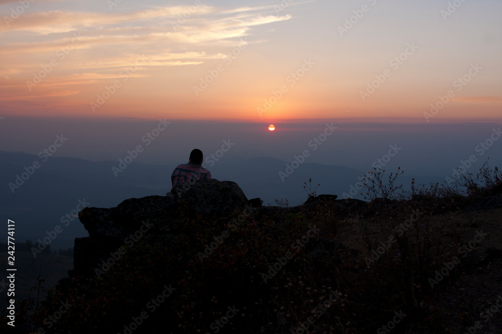 A man in silhouette watching the sunset
