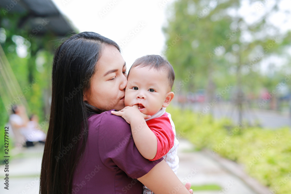 Portrait of Infant baby boy is sucking finger with Asian mother carrying. Portrait of Infant baby boy is sucking finger with Asian mother carrying.
