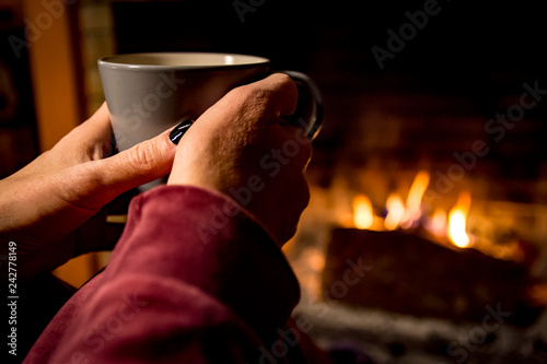 woman is warming in a fireplace