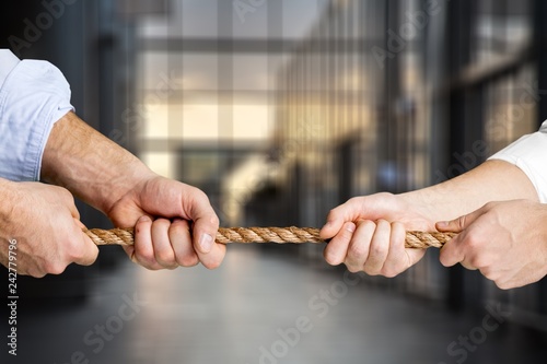 Tug war, two businessmen pulling a rope in opposite directions