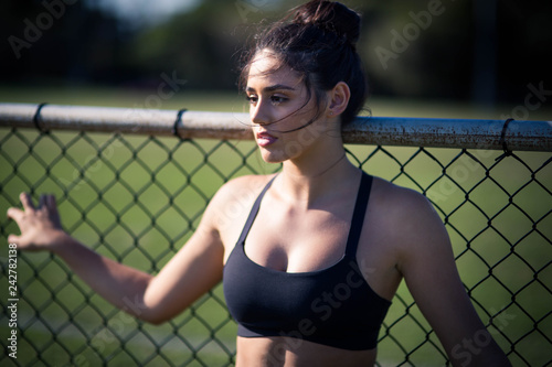 Fitness active wear woman posing on fence exercise park fence grass © velezco
