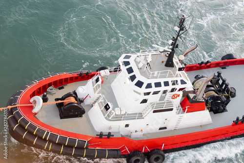 Red and white tug boat mooring