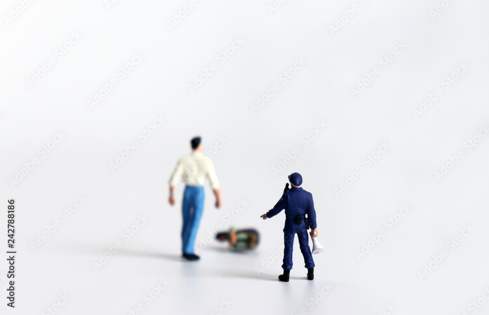 The concept of domestic violence. A miniature man is standing with a miniature woman and a miniature police. The concept of domestic violence. A miniature man is standing with a miniature woman and a miniature police.
