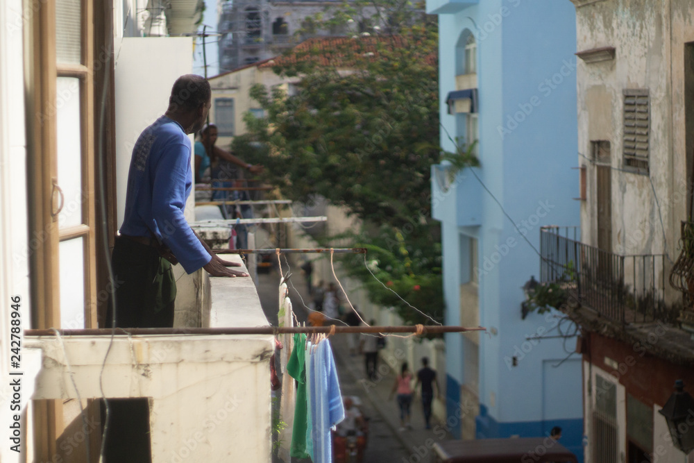 Man leaning on balcony in Havana, Cuba