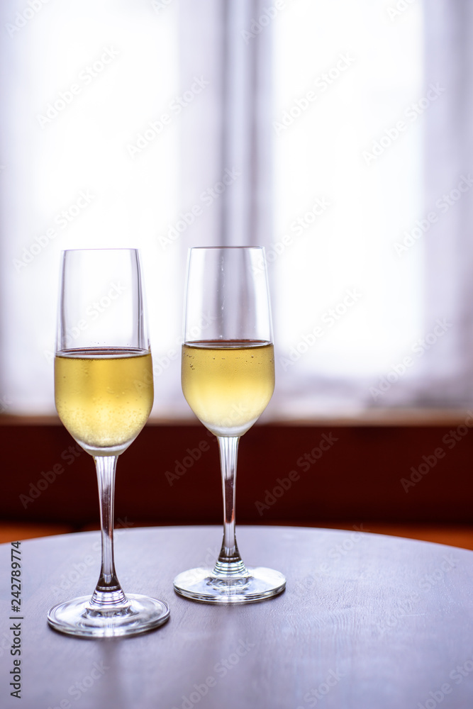 champagne glass with blurred curtain background