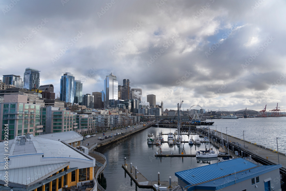 Downtown Seattle with beautiful architect, boat dock and dramatic clouds