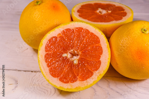 Ripe juicy grapefruit on a white wooden table