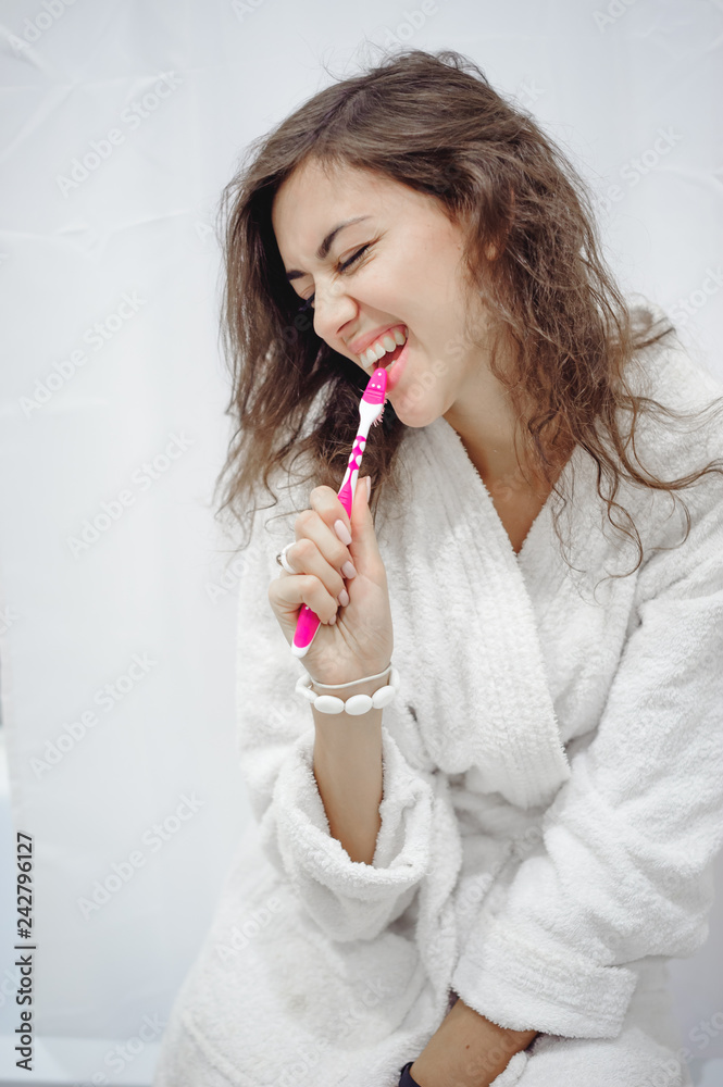 portrait of a beautiful woman in the bathroom. cheerful young girl washes, brushes her teeth with a toothbrush portrait of a beautiful woman in the bathroom. cheerful young girl washes, brushes her teeth with a toothbrush