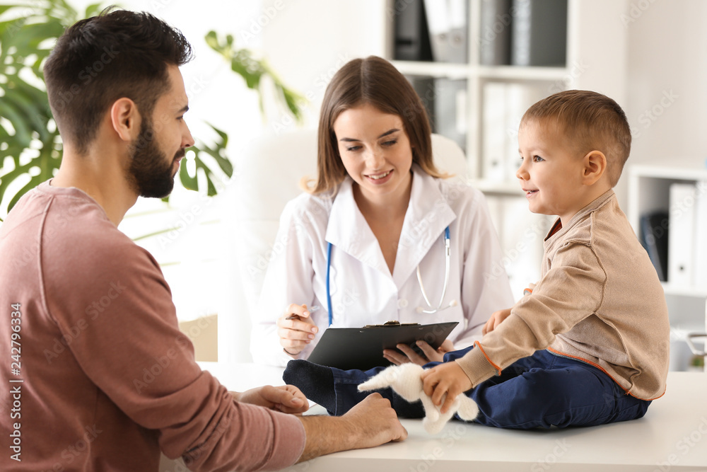 Young father with his little son visiting doctor in clinic Young father with his little son visiting doctor in clinic