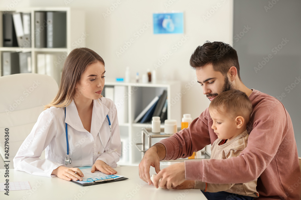 Young father with his little son visiting doctor in clinic Young father with his little son visiting doctor in clinic