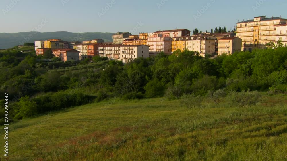 Pan Up: Grassy Field to the Backside of Apartment Pan Up: Grassy Field to the Backside of Apartment