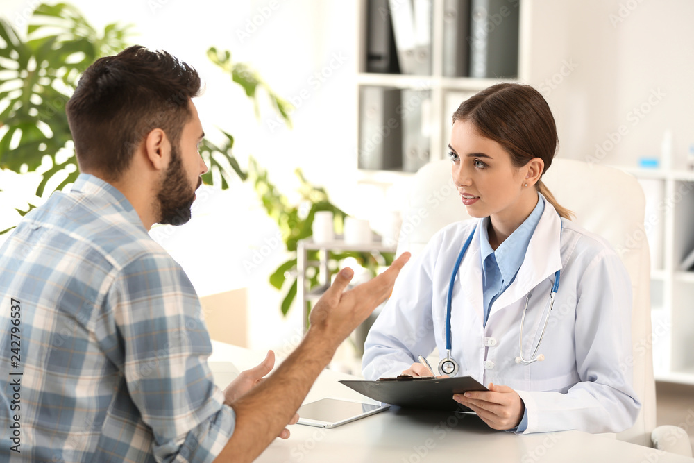 Female doctor working with male patient in clinic Female doctor working with male patient in clinic