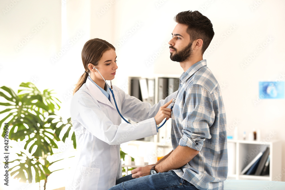 Fototapeta premium Female doctor working with male patient in clinic