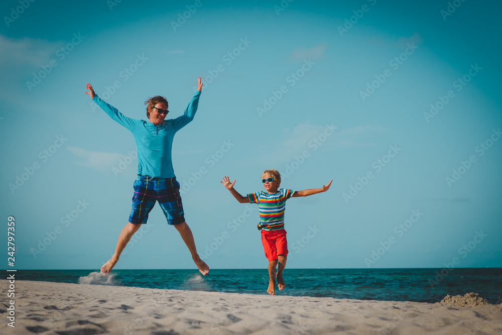 father and son have fun jump at tropical beach father and son have fun jump at tropical beach