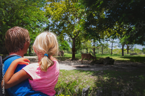 Photography father and little daughter loooking at wild animals on safari tour