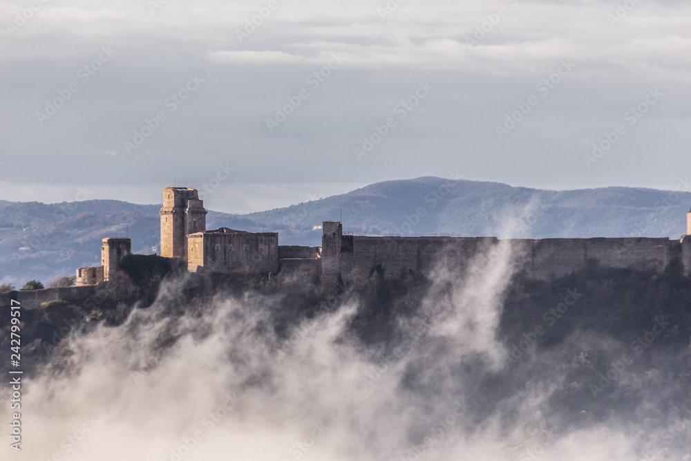 A view of Rocca Maggiore castle in Assisi (Umbria, Italy) in the middle of fog