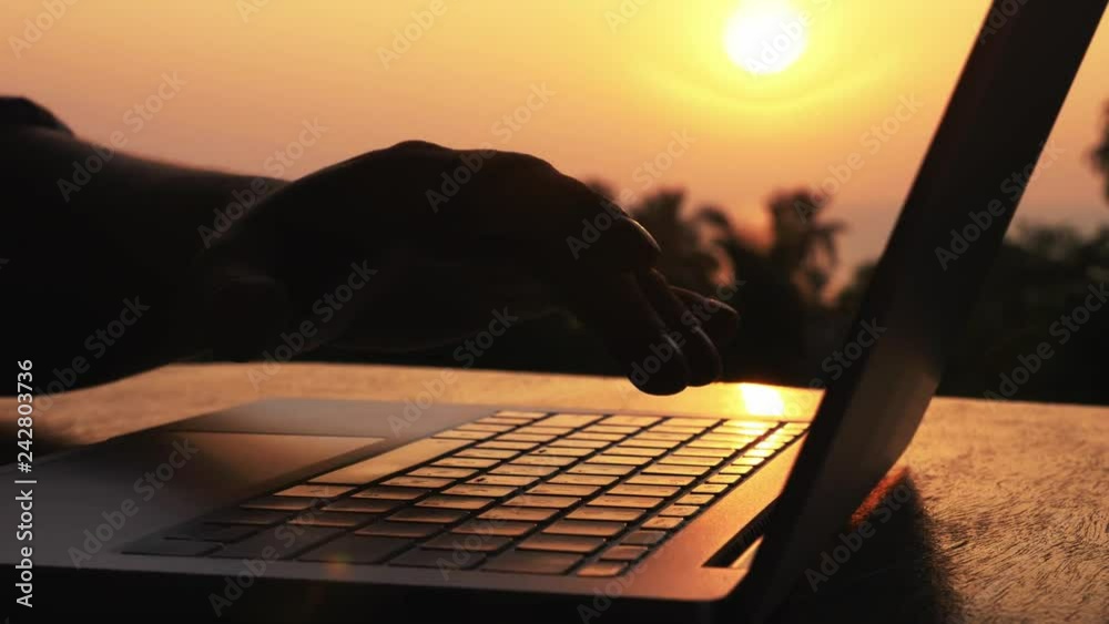 Close-up of silhouette male hands opening laptop and starting work