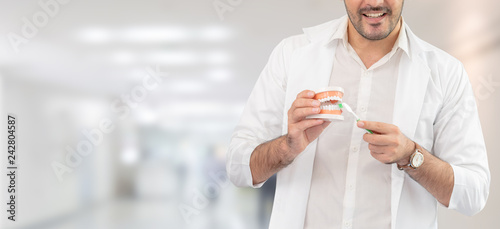 Young male dentist working in dental clinic. Dentistry care and medical service concept. photo