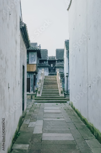 Path leading to bridge between traditional Chinese black and white houses, in downtown Jiaxing, China