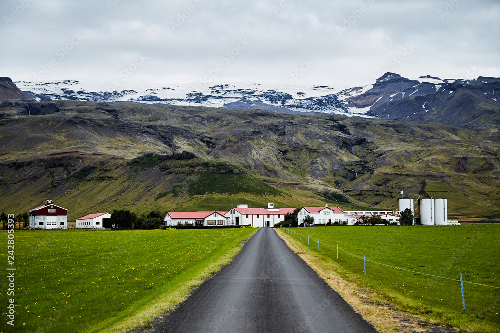 Beautiful landscape in Iceland. Road with mountain views and small houses.