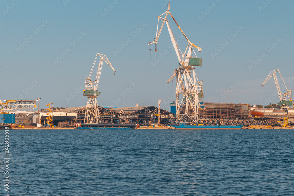 dockyard in Pula with cranes while loading a ship, industry