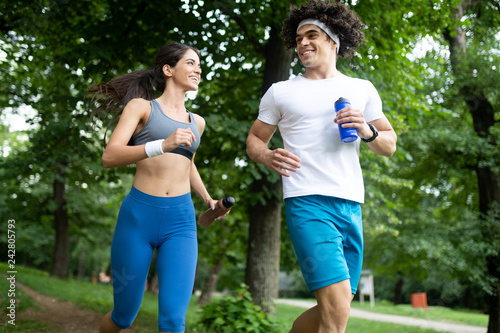 Happy young people jogging and exercising in nature